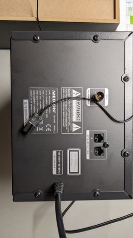 Rückseite der Anlage mit zwei Buchsen für zwei Boxen, darauf der Stecker einer Box